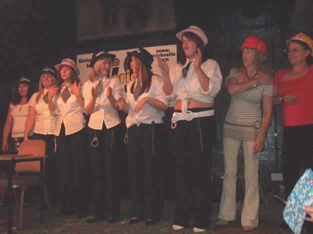 A group of girls standing in a line dressed as cops.