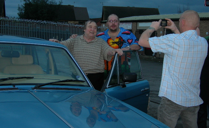 Bernard Manning with hand raised to accept the mike from Pav